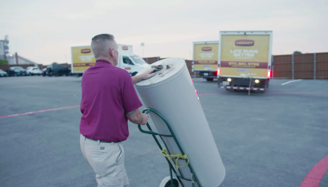 Plumber from Legacy Plumbing delivering a water heater to be installed