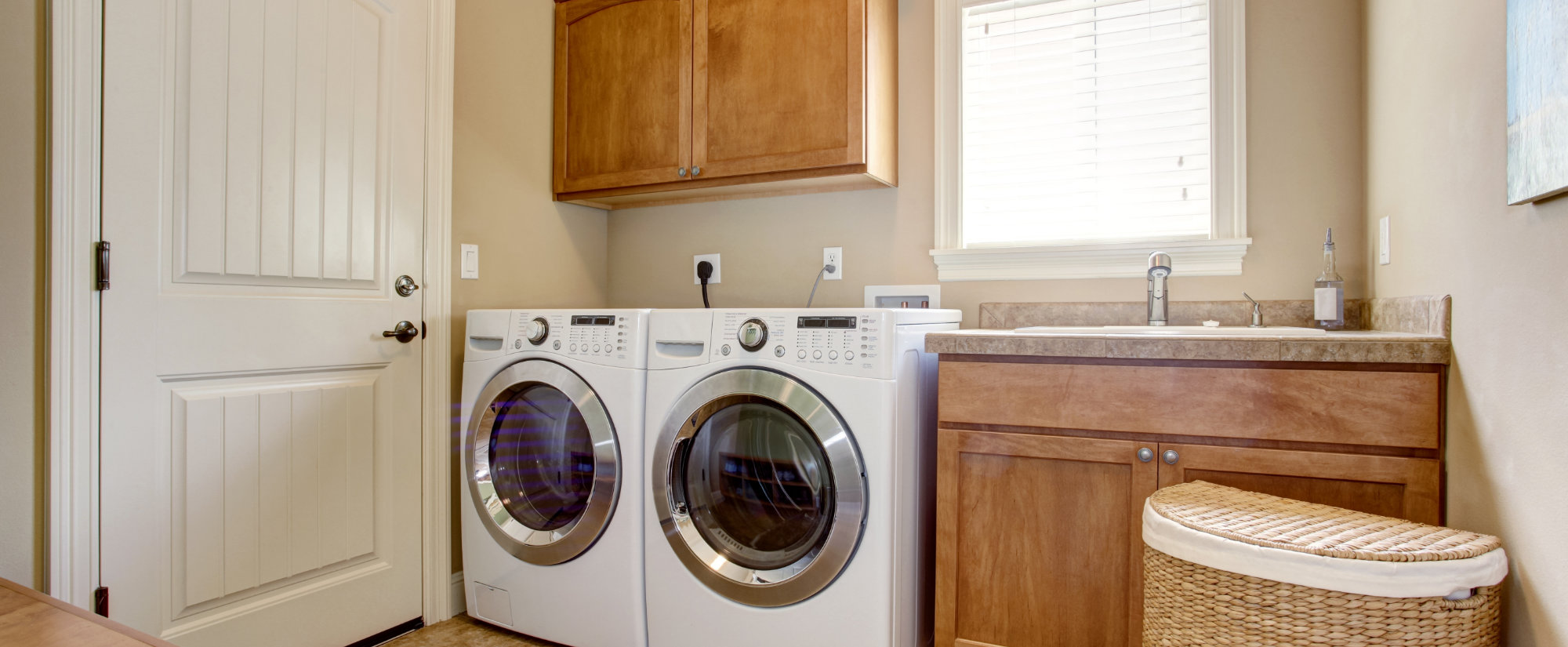 Picture of a laundry room with front load washer and dryer and a utility sink